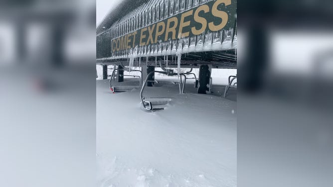 Chairs of ski lift buried in the snow.