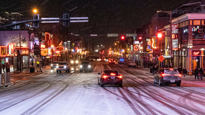 Snow falls on Broadway, a popular tourist street in Nashville, Tennessee, on December 22, 2022.