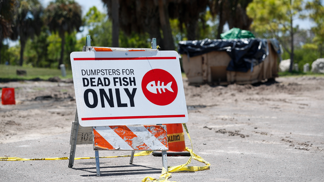 FILE - A sign is posted for depositing dead marine life from the Red Tide bacteria into dumpsters, is seen at Maximo Park on July 21, 2021 in St Petersburg, Florida.