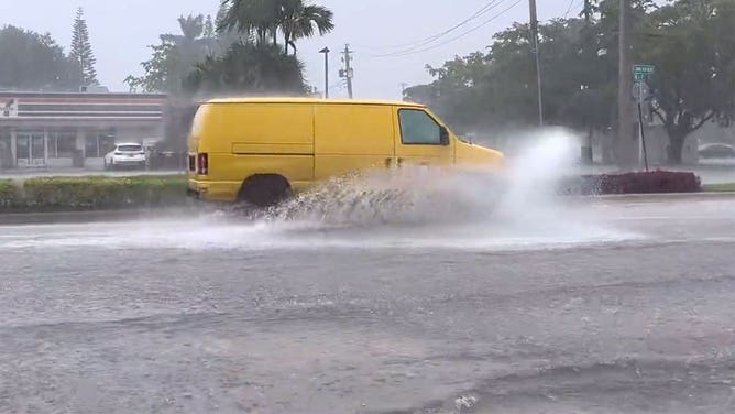 A van navigates a flooded street in Dania Beach, Florida, on April 12, 2023.