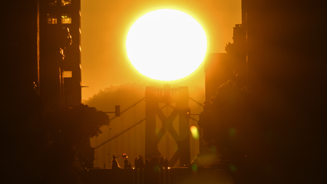 Sun rises over the Bay Bridge and California Street as called 'California Henge' in San Francisco, California, United States on April 9, 2023.