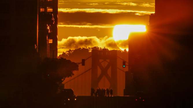 Sun rises over the Bay Bridge and California Street as called 'California Henge' in San Francisco, California, United States on April 8, 2023.