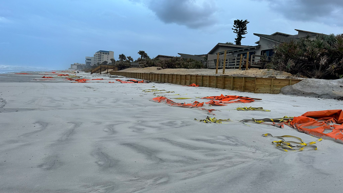 Volusia County in Florida is taking down barriers called tiger dams that are meant to protect homes following hurricanes Ian and Nicole. Along New Smyrna Beach, the dams are deflated and damaged, and homes that were torn apart during the hurricanes are exposed to the elements, with waves pulling more debris further out to sea.