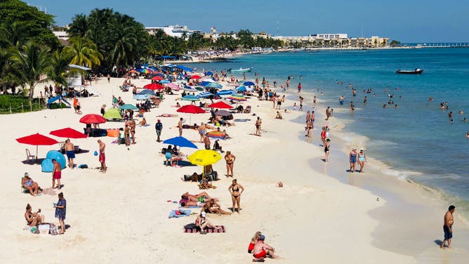 People enjoy a day on the beach in the seaside tourist resort of Playa del Carmen.