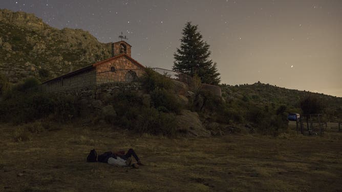 People lie on the ground to watch a meteor shower in Spain. 2020.