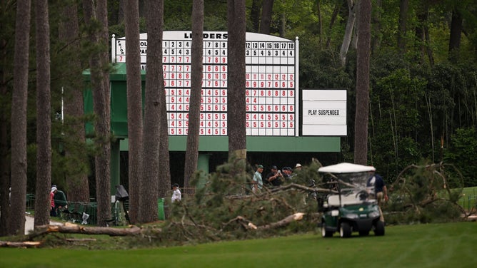 Signage that reads 'Play Suspended' on the leaderboard as fallen trees are seen on the 17th hole during the second round of the 2023 Masters Tournament at Augusta National Golf Club on April 07, 2023 in Augusta, Georgia.