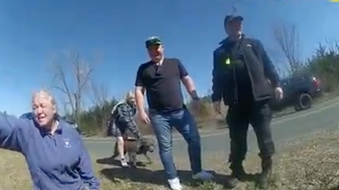 The mother (left), along with her daughter and dog Blue (background), stand with their rescuers.