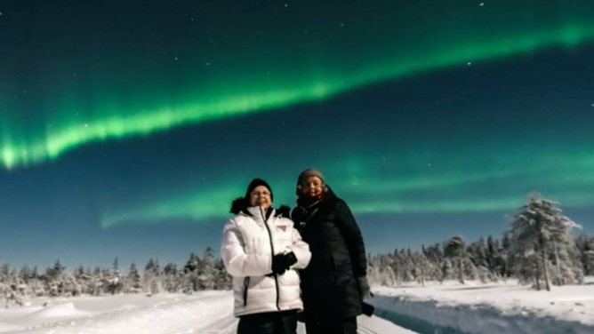 Hazelip and Hamby with the Northern Lights above them.