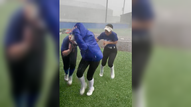 The young women try to protect each other from the hailstorm.