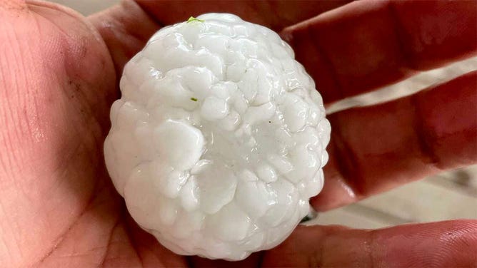 A person holds a hail stone that fell in Barton County, Missouri, on April 15, 2023.
