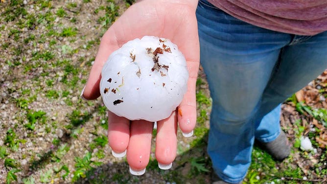 A person holds a large hailstone that fell near Lamar, Missouri, on April 15, 2023.