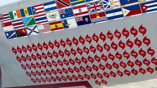 Flags of countries visited by a WP-3D Orion airplane used by NOAA's Hurricane Hunters are seen in Houston on May 1, 2023, along with hurricane emblems for the storms the aircraft has been used to invesitgate.
