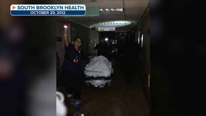 Pushing a patient through the dark, flooded halls of the the hospital during Hurricane Sandy. October 29, 2012.