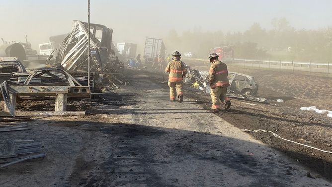 First responders are seen walking through crash debris on I-55 in Illinois on Monday, May 1, 2023.