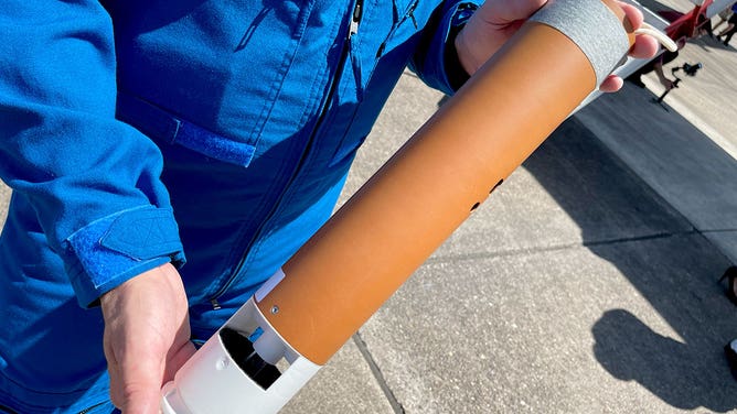 A member of NOAA's Hurricane Hunters shows a dropsonde that is used aboard a WP-3D Orion aircraft. This photo was taken in Houston, Texas, on May 1, 2023.