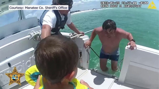A father enters a boat after he and his son were rescued when they were pulled offshore by a strong rip current in Florida over the weekend.