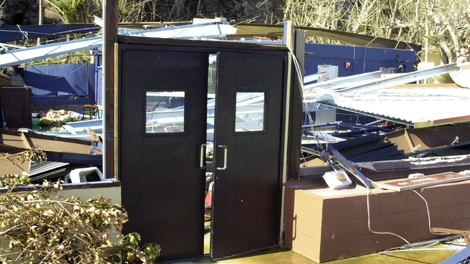 FILE - ANDERSEN AIR FORCE BASE, GUAM - DECEMBER 8: These doors, which once allowed access to Oscars on Terague Beach on Andersen Air Force Base, Guam, are one of the few things left standing after Super-typhoon Pongsona struck the island December 8, 2002. Members of Team Andersen joined together to clean the base and restore it to pre-typhoon condition. Super-typhoon Pongsona had peak gusts of 180 mph and caused power outages, a fuel shortage, and island wide damage.