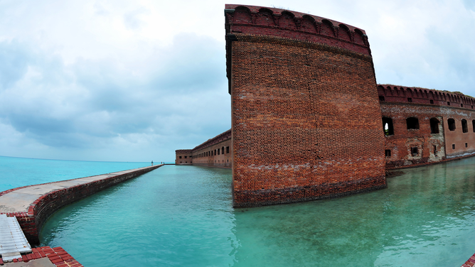 FILE - Tourists walk along the sea wall surrounding Fort Jefferson February 15, 2016 in the Dry Tortugas National Park about 70 miles (113 km) west of Key West, Florida in the Gulf of Mexico.