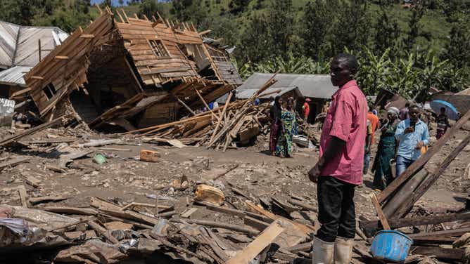 Family members and residents of the two villages affected by the floods look up at the damage caused by the disaster in Nyamukubi, eastern Democratic Republic of Congo, May 8, 2023. 