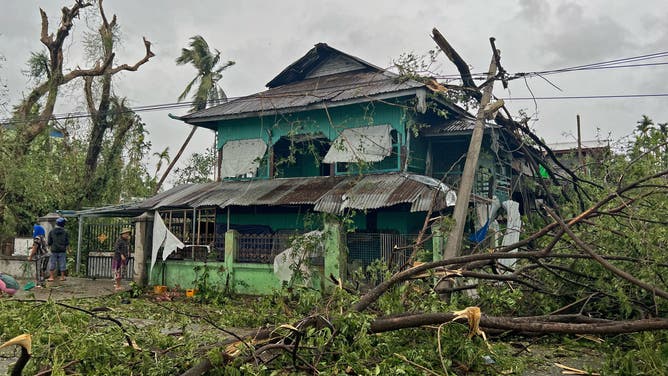 Local residents check the damages after Cyclone Mocha crashed ashore, in Kyauktaw in Myanmar's Rakhine state on May 14, 2023. Cyclone Mocha crashed ashore in Myanmar and southeastern Bangladesh on May 14, uprooting trees, scattering flimsy homes in Rohingya displacement camps and bringing a storm surge into low-lying areas.
