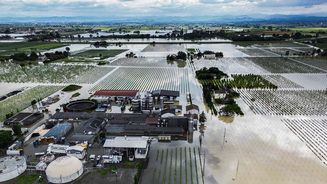 An aerial view shows a flooded pig farm and surrounding fields in the town of Lugo on May 18, 2023, after heavy rains caused flooding across Italy's northern Emilia Romagna region.