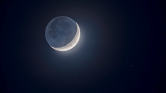 FILE - Earthshine lights the
