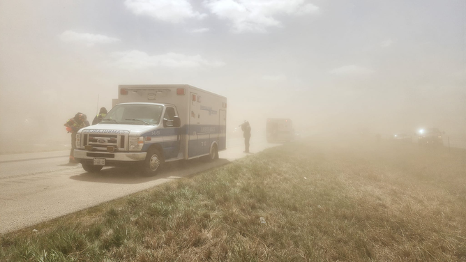 An ambulance is seen near the scene of a massive pileup on I-55 in Illinois after a dust storm on May 1, 2023.