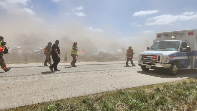 Flames can be seen among the wreckage of crashed vehicles after a pileup on I-55 in Illinois after a dust storm on May 1, 2023.