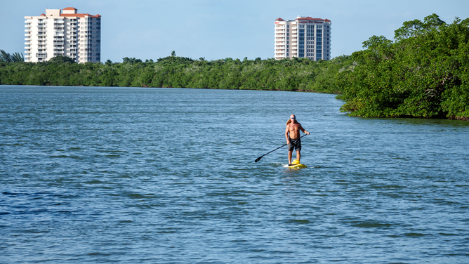 FILE - A man on a paddleboard at Lovers Key Carl E. Johnson State Park.