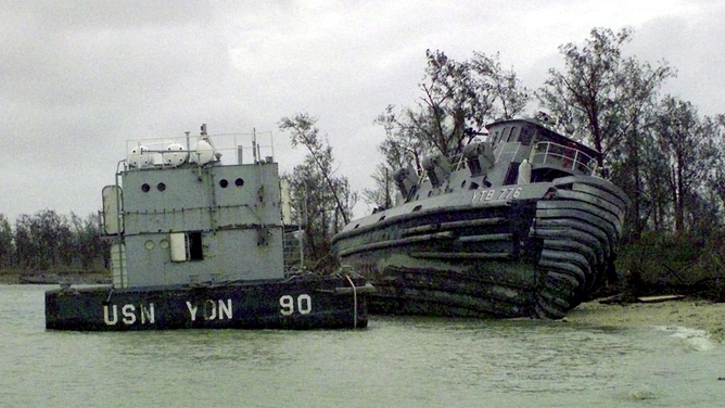 FILE - A Naval Station Marianas Guam barge and yard tug ran aground by Super Typhoon Paka in December 1997.