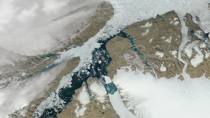 FILE - The giant iceberg that broke off Greenland’s Petermann Glacier in mid-July 2012 continued moving down the fjord at the end of the month. The Moderate Resolution Imaging Spectroradiometer (MODIS) on NASA’s Terra satellite captured this natural-color image on July 30, 2012. By the time MODIS acquired this image, the iceberg—named PII-2012—had traveled roughly 22 kilometers (14 miles) from the edge of the Petermann Glacier and had rotated counter-clockwise.