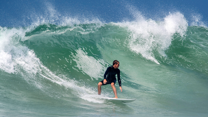 FILE - A surfer rides a wave at Salt Creek Beach in Dana Point as a large swell began to move on shore, on Thursday, July 5, 2018.