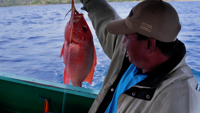 A man holds up his catch.