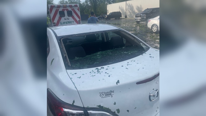 The back windshield that had fallen in from hail damage. Hail also chipped off the white paint on the car. June 14, 2023.