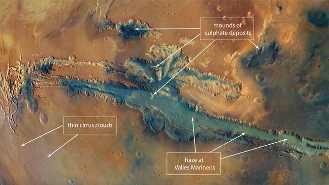 This image is a close-up of the ESA Mars Express mosaic image, with stretched contrast, and shows the canyon system Valles Marineris with annotated surface details: sulphate deposits, haze and fog, and cloud cover.