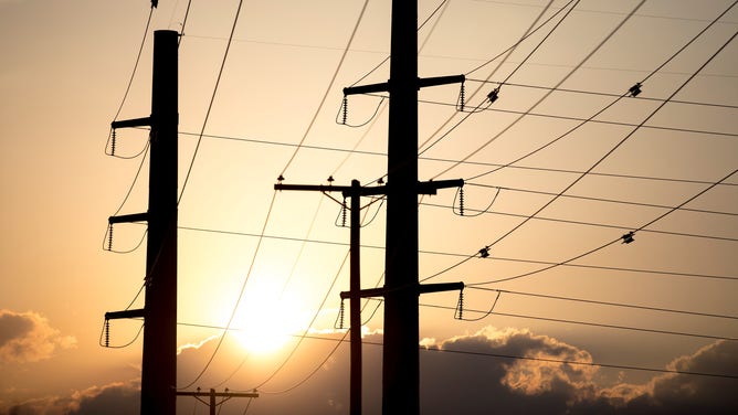 FILE - The sun sets behind power transmission lines in Texas, the United States on July 11, 2022.