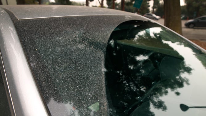 A layer of ash from a wildfire rests on a car.