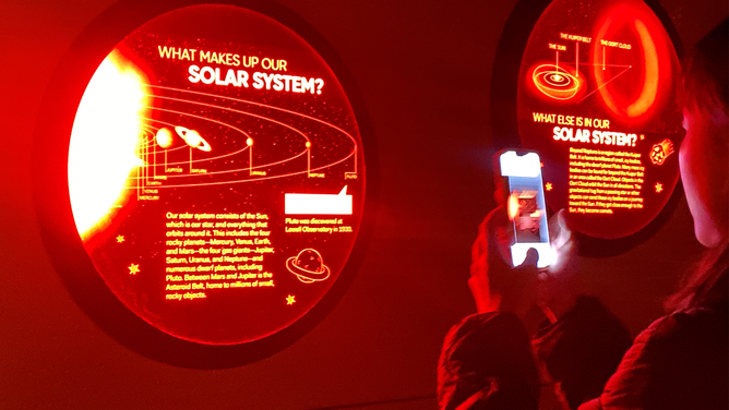 FILE - A visitor takes photos at Lowell Observatory in Flagstaff, Arizona, the United States, on Nov. 10, 2022. Championed by dark sky advocates and bolstered by economic incentives, towns and parks around the U.S. West are making strides to preserve night sky views.