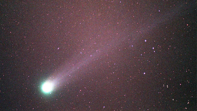FILE - The Comet Hyakutake passes through the night sky 25 March over Merritt Island, Florida near the Kennedy Space Center.