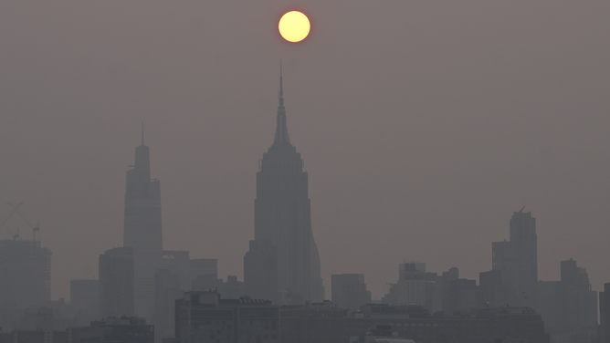The sun is shrouded as it rises in a hazy, smoky sky due to the Canadian wildfires in New York City of United States on June 07, 2023.