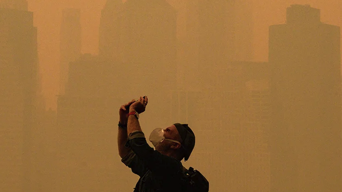 People take photos of the sun as smoke from the wildfires in Canada cause hazy conditions in New York City on June 7, 2023.