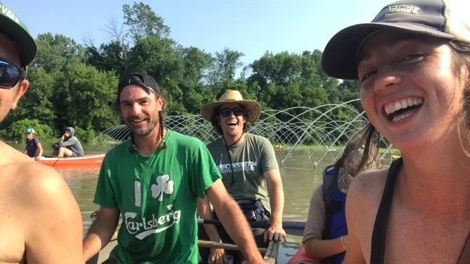 Pitchfork Farm co-owner Eric Seitz and farm staff paddle through the flooded vegetable fields in Vermont.