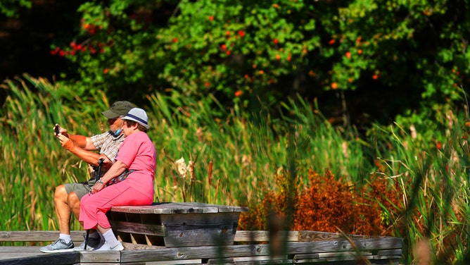 NATICK, MA - OCTOBER 1: A couple takes a selfie on the boardwalk beside the Charles River at the Broadmoor Wildlife Sanctuary in Natick, MA on Oct. 1, 2020. (Photo by Lane Turner/The Boston Globe via Getty Images)