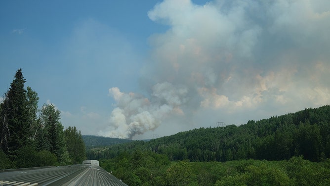 Smoke from a wildfire is seen in the distance near Sheraton (west of Fraser Lake), British Colombia, Canada, taken from a passenger train on the Prince George - Prince Rupert line on July 10, 2023.