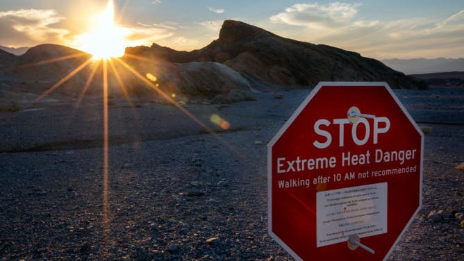A sign warns of extreme heat danger at Zabriskie Point on Sunday, July 16, 2023, in Death Valley, CA. Even at dusk, the temperature is 123 degrees. (Francine Orr / Los Angeles Times via Getty Images)