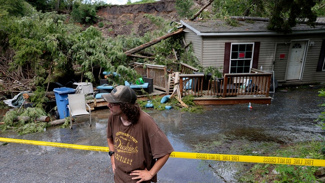 Ethan Poploski stood in front of his family's home which had been destroyed by a landslide overnight.