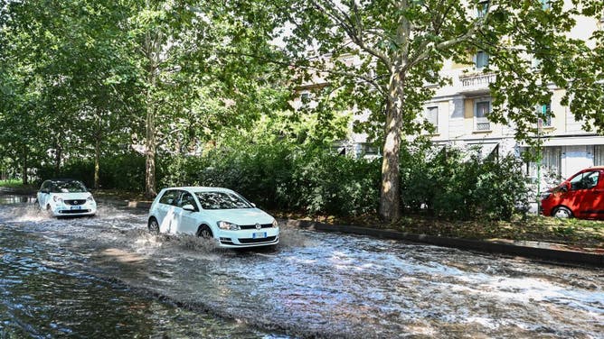 Cars move on a flooded road as heavy rain and wind cause damages in Milan, Italy on July 25, 2023.