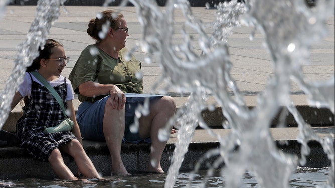 Visitors cool themselves off at the fountain of the World War II Memorial on July 28, 2023 in Washington, DC. Extreme heat is forecasted in the DC area thru Saturday with a heat index reaching up to 110 degrees.