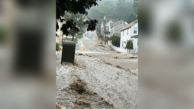 A photo showing water rushing down Drew Road in Highland Falls, New York, on Sunday, July 9, 2023.