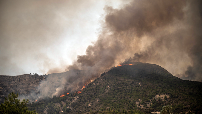 This photograph taken on July 26, 2023, shows an ongoing fire near Vati, on the Greek Aegean island of Rhodes. Wildfires have been raging in Greece amid scorching temperatures, forcing mass evacuations in several tourist spots including on the islands of Rhodes and Corfu.